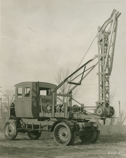 A truck with an attached crane manufactured by the Winther Motor and Truck Company.