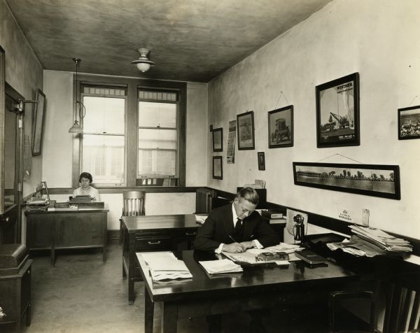 Two unidentified workers in an office at Winther Motor and Truck Company.