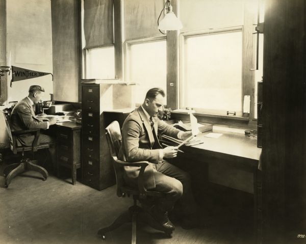 Mr. Charles Abbott and another male worker in the Timekeeper's office.