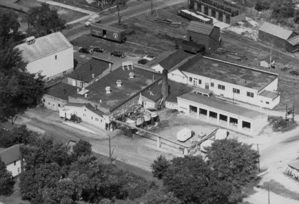 Aerial view of Brodhead Cheese Factory with milk truck on ramp and whey tanks in the center.  A boiler room was added later and the factory was moved outwards to gain more space.