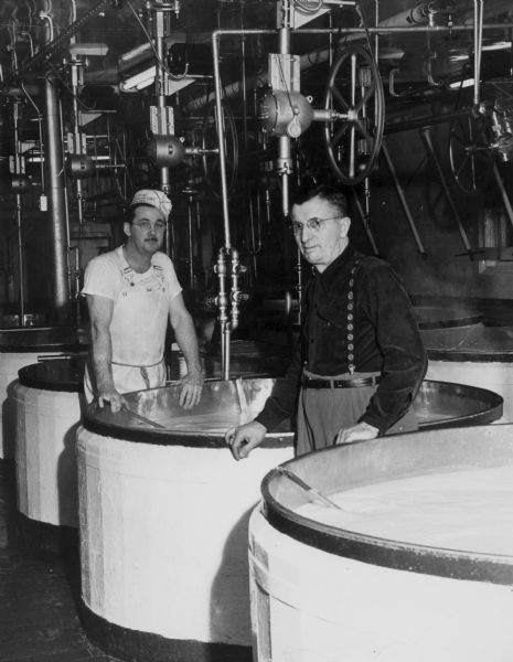 Kenneth Clark and Casper Jaggi standing next to vats at the Brodhead cheese factory.