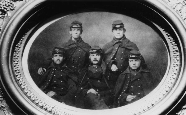Oval-framed group portrait of members of the 1st Illinios Light Artillery Battery Company B from Kenosha, Wisconsin. From left to right: Douglas Newell, C.D. Dana, Henry Clark, W.T. Shepherd, Walter Stebbins.