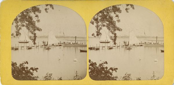 Stereograph of a Lake Monona pier with sailboats and a steamboat.