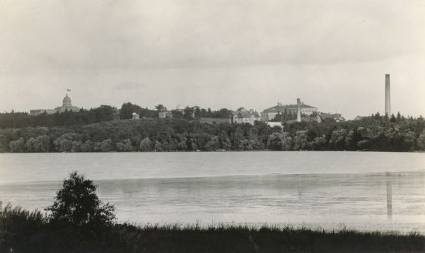 The University of Wisconsin from Picnic Point. Buildings that can be seen are Bascom Hall with dome, the Students' Observatory, Washburn Observatory, the Dairy Building, Agricultural Hall and the chimney from the power station.