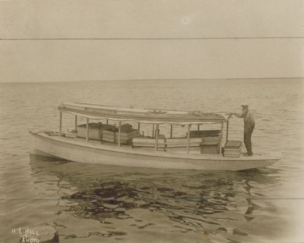 Man transporting beehives down the Indian River via boat.