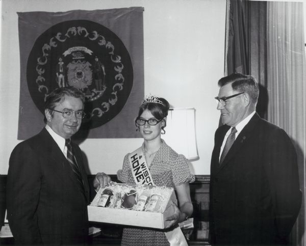 Wisconsin Honey Queen standing between Wisconsin Governor Patrick Lucy and an unknown man.