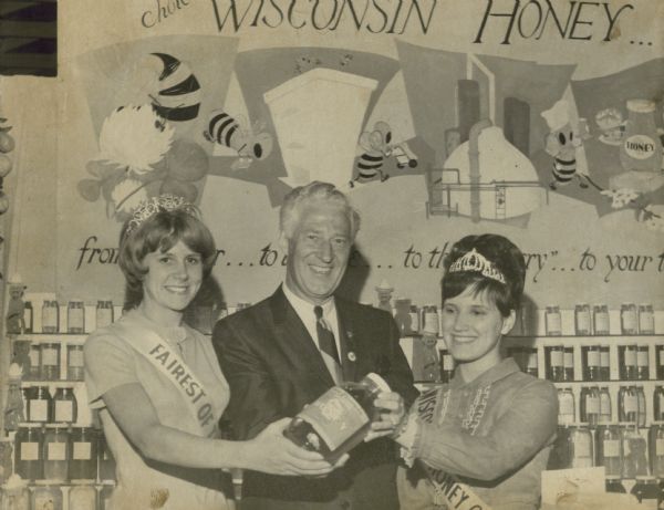 Walworth Fairest of the Fair, Governor Knowles and the Wisconsin Honey Queen all holding a bottle of honey at the Walworth County Fair.