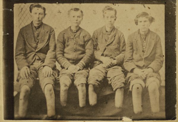 A carte-de-visite of John Schmit, Freddy Hill, Leland Fay and George Schmit, who were frozen on the night of March 10th and 11th, 1876, on the Green Bay and Milwaukee Railroad bridge over Elk Creek during the Great Freshet (flood) of 1876. Their feet were amputated due to exposure to the cold.