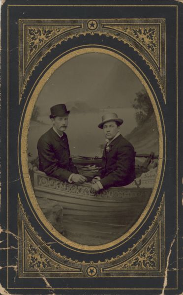 Tintype (ferrotype), studio portrait of two men in a boat in front of a painted backdrop.