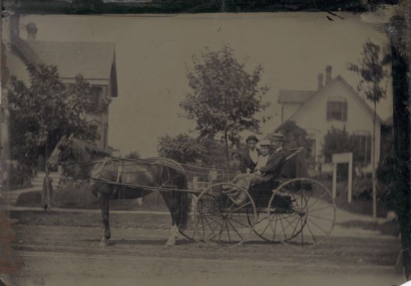 Tintype (ferrotype) of two men and a woman in a buggy.