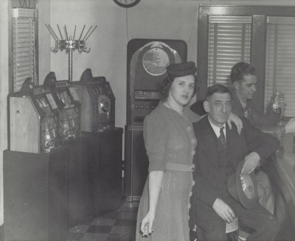 A man and woman posed at the bar in Nesbitt's Highway Tavern, on Highway 42, North of Kenosha. Gambling machines can be seen on the left.