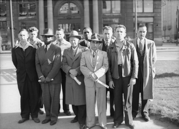 Striking members of Local 1568, United Steelworkers of America (Milwaukee Steel Division, Grede Foundries), after their arrest on the picket line. Left to right, front row: Perry Sanders, Frank Jenkins, Charles Hinz, Frank Musarra, Eugene Kowalczewski.  Back row: Joe Krolski, Norman Nelson, Roy Jones, Walter Risch, Anthony G. Repensek.
