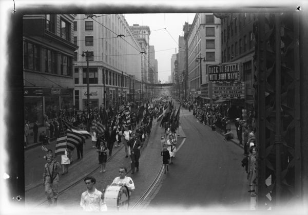 Workers and soldiers marched together in Milwaukee's first Labor Day parade in many years, sponsored by the CIO, to demonstrate the common interest of all of the American people: jobs, security, peace. Shown above is the Local 75, UAW-CIO (Seaman Body) contingent which led off the parade with massed flags of all nations and the drum corps of the Army and Navy Union.