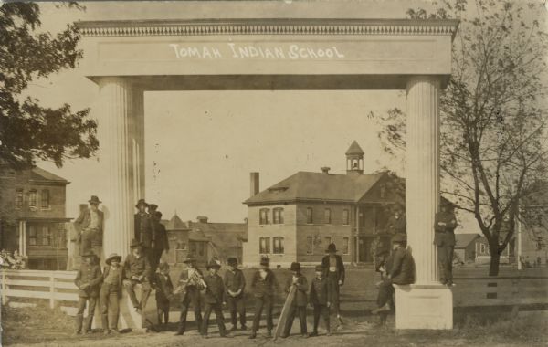 Tomah Indian School with boys standing in front of the entrance sign.