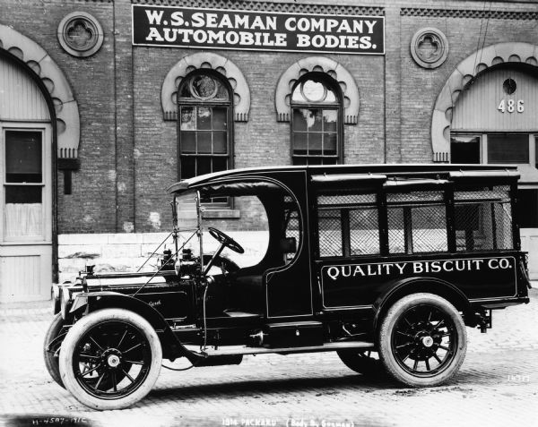 A 1914 Packard delivery truck for Quality Biscuit Company, sitting in front of the W.S. Seaman plant.  The car's body was produced by the W.S. Seaman Company.