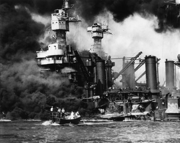 Sailors in a motor launch attempt a rescue of survivors from the water alongside the sunken battleship USS <i>West Virginia</i> during or shortly after the Japanese air raid on Pearl Harbor.  Seen behind the USS <i>West Virginia</i> is the battleship USS <i>Tennessee</i> which took a few hits to its main guns, some burning to the hull through oil fires, and some deck burning from debris that came from the USS <i>Arizona</i>.  The USS <i>West Virginia</i> was hit by nine torpedoes and began taking on water. The crew used counter-flooding to stabilize the ship, but eventually the USS <i>West Virginia</i> sank.