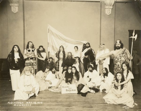 A group of Jewish people dressed as Old Testament characters standing in front of the flag of Israel .