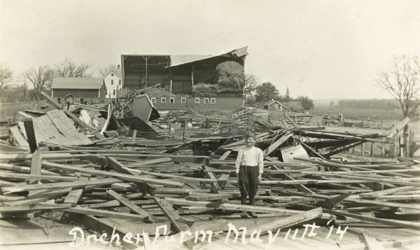 A boy standing in the midsts of the ruins of the Dreher Farm after it was hit by a tornado.