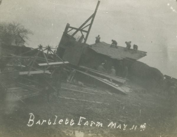 Men clearing the ruined barn on the Bartlett Farm after it was hit by a tornado.