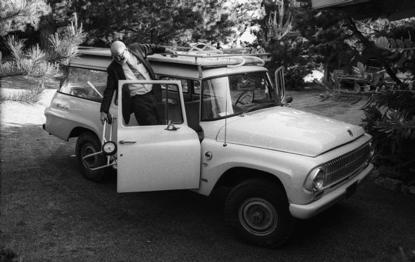 Photographer Ansel Adams loading his International Travelall station wagon at his home.