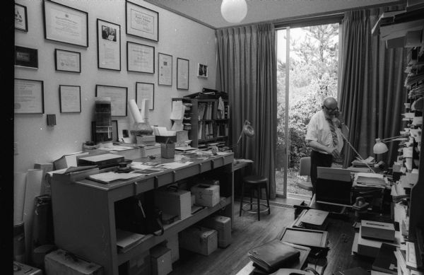 Photographer Ansel Adams talking on the telephone in his office at his home.