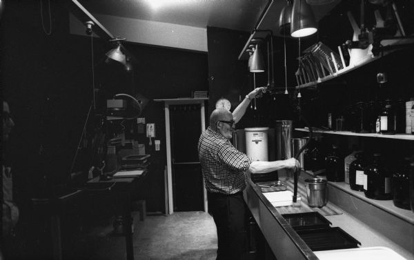 Photographer Ansel Adams working in his darkroom at his home.