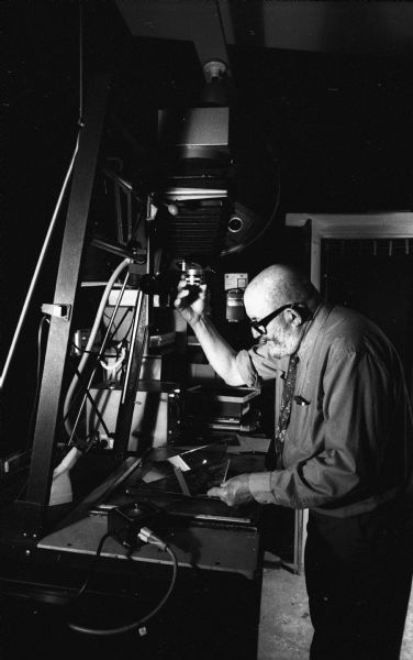 Photographer Ansel Adams makes an adjustment to the exposure while making a print in the darkroom at his home.
