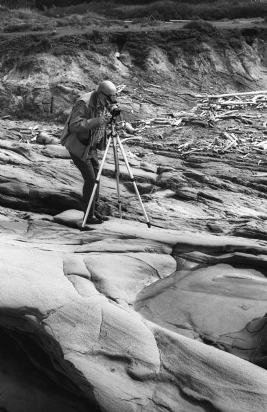 Ansel Adams prepares to photograph a tide pool with his tripod mounted Hasselblad camera.