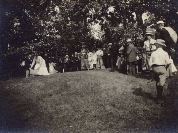 Miss Pauline Buell removes an American flag from the Vilas Circle Bear Mound following the unveiling of a historic tablet on July 29, 1910.