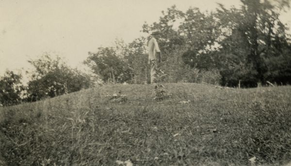 A man stands atop a conical burial mound at the Williams South mound group near Lake Kegonsa State Park.