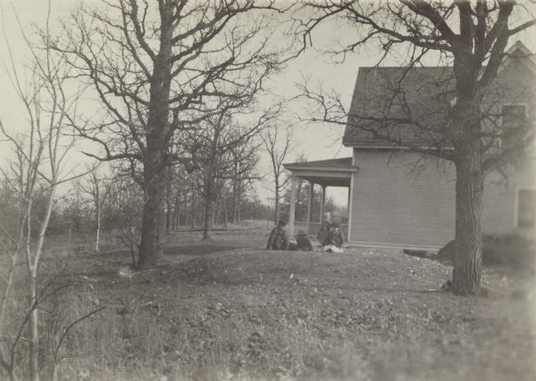 Children sit atop a conical burial mound in a farmyard at Merrill Springs, on the south shore of Lake Mendota. (Also known as Merrill's Spring.)