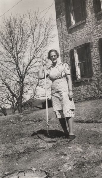 Isabel Bacon La Follette holding a rake on the farm Philip purchased in northwestern Dane County.