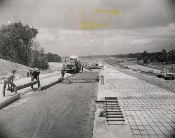 Concrete paving operation near the intersection of I-90 and U.S. Highway 12 in Sauk County. Traffic flows along the old highway to the right of the new construction.