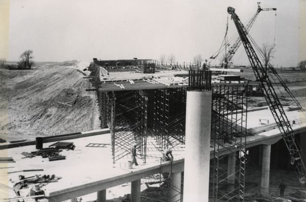 Construction at an unidentified interstate highway intersection in Wisconsin showing the scaffolding in place on a completed span on which the upper span will be constructed