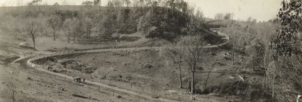 Panoramic view of the section of State Highway 115 in Richland County known as Muscoda-Richland Center Road.  Grading and improvement of this hilly section known as Paul's Hill is almost complete although a horse-drawn road grader can be seen in the left foreground.