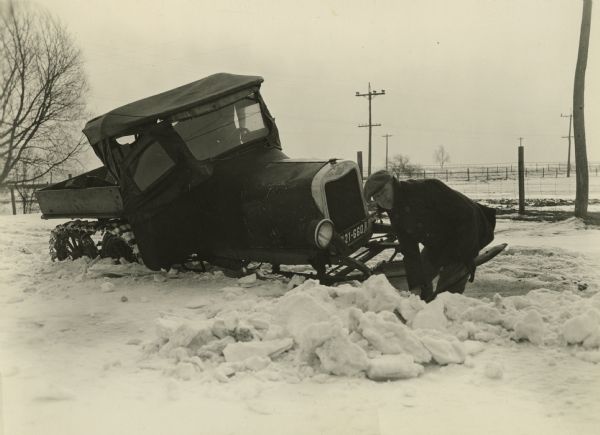 A rural electric service man stuck in the snow while making his rounds during the winter of 1926-1927 despite the fact that his Ford truck was mounted on runners and there were chains on his wheels.