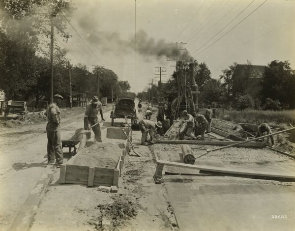 Road construction crew at work on the Chicago-St. Francis Road in Milwaukee County.  This road was constructed with bulk cement using an integral curb.