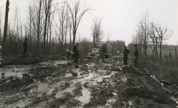 Impassible muddy conditions along State Highway 13 between Butternut and Glidden, with a truck of the Flambeau Freight Lines stuck up to its axles.