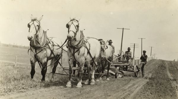 The function known as patrol maintenance is seen performed in St. Croix County along State Highway 12 by a four-horse team pulling a road grader.