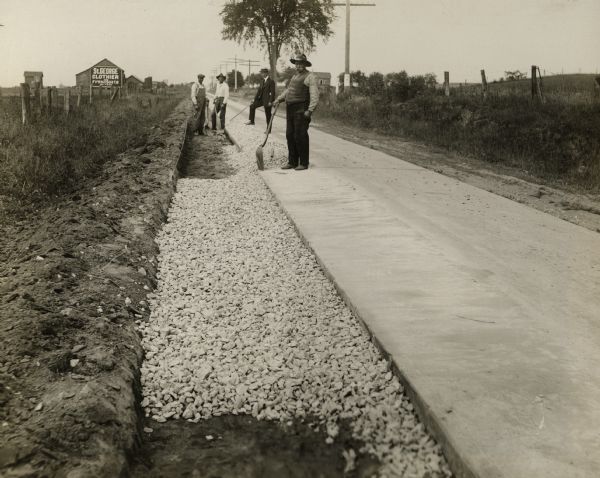 View of a road crew along State Highway 15 at work constructing a trench for a penetration type shoulder near Kaukauna.