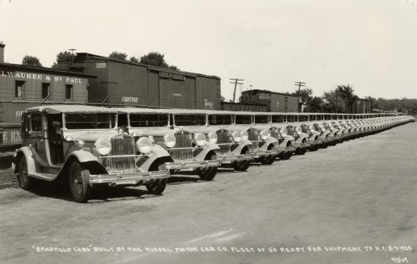 A line of fifty "Bradford Cabs" manufactured by the Kissel Motor Car Company of Hartford, Wisconsin. Caption reads: "'Bradford Cabs' built by the Kissel Motor Car Co. Fleet of 50 ready for shipment to N.Y."