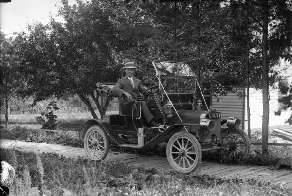 Although this photograph is unidentified, license plate records in the Wisconsin State Archives indicate that in 1912 the car (a Maxwell) was registered by Charles Vlach of Kewaunee County. It is probably Vlach who is pictured here. The car appears to be a sporty, two-seat 1910 runabout.