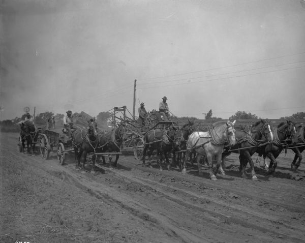 Advanced, horse-drawn road grader in action.  Here, excess dirt moves up a conveyor belt and is dumped in a wagon next to the grader.