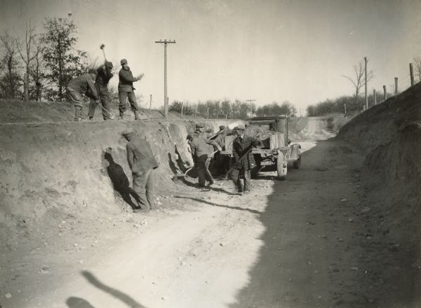 CWA road crew leveling a grade on a county road near Westfield.  The CWA undertook many road and utility projects during the Great Depression in order to provide relief for out of work men.  Such projects were sometimes referred to as "make work," but it is certainly clear from the absence of power equipment, that the projects were clearly "work."