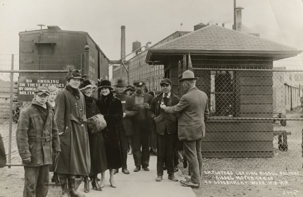 Workers leaving the Kissell Motor Car Company have their identification badges checked.  The Hartford company was then building trucks of the Four Wheel Drive Company of Clintonville for the Army.  Women worked in the Kissel factory during the war, but it is not clear if the women in this photograph are workers or simply present to greet the workers.