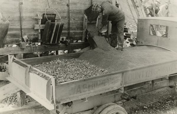 Washington County highway worker filling a Kissel-built truck with gravel and crushed rock.