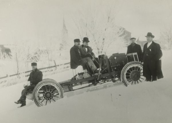 Five men pose with the first successful four-wheel drive vehicle, which was made in Clintonville in 1909. The inventor, Otto Zachow, is the man seated at the rear of the steam-powered vehicle.
