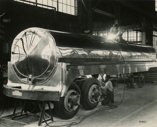 Welding a milk truck at the Heil Corporation in Milwaukee.  The Heil company was founded by German-born Julius P. Heil in 1901.  As the Heil Rail Joint Weld Co.,  Heil successfully pioneered the new welding technology, eventually becoming wealthy as a manufacturer of truck trailers and bodies and refuse collecting vehicles.  He served as governor of Wisconsin from 1939 to 1943.  In 1926 the company introduced the first tin-lined steel milk tank trucks.  The company was sold to Dover Industries by the Heil family in 1993. Today its manufacturing takes place in Tennessee, Texas, and other locations around the world.