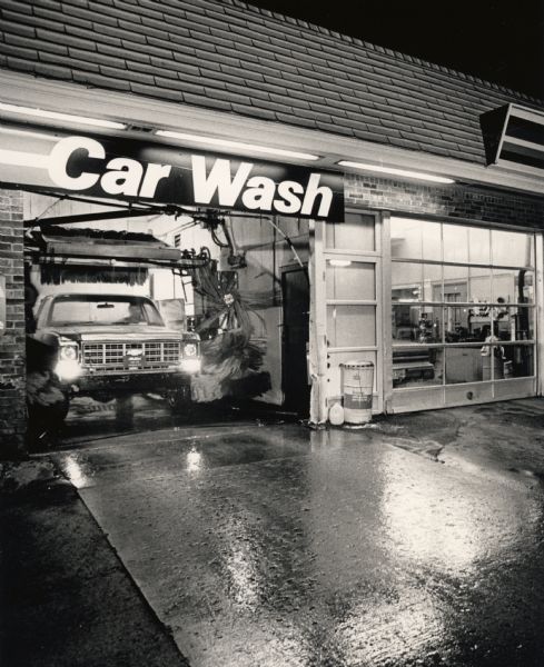 Self-service car wash at Slattery's Amoco Service Station. A late evening customer takes advantage of a break in the normal January temperatures to wash rust-causing road salt from his Chevrolet truck.
