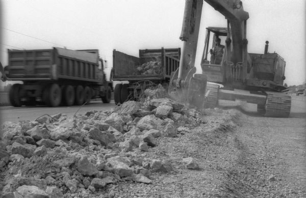 A Caterpillar shovel loads excavated concrete and rebar on the back of a dump truck during the course of reconstruction work on one of Wisconsin's interstate highways.
